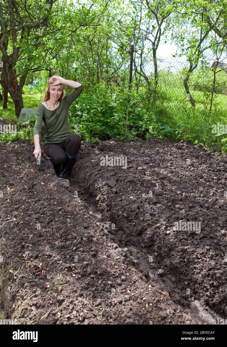 The young woman couch a garden-bed Stock Photo