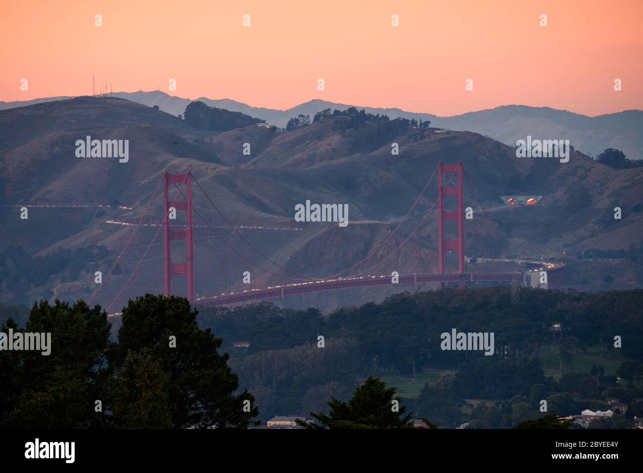 Senset dusk at Golden Gate Bridge, San Francisco, California. Shot from Twin Peaks with long range zoom. Stock Photo