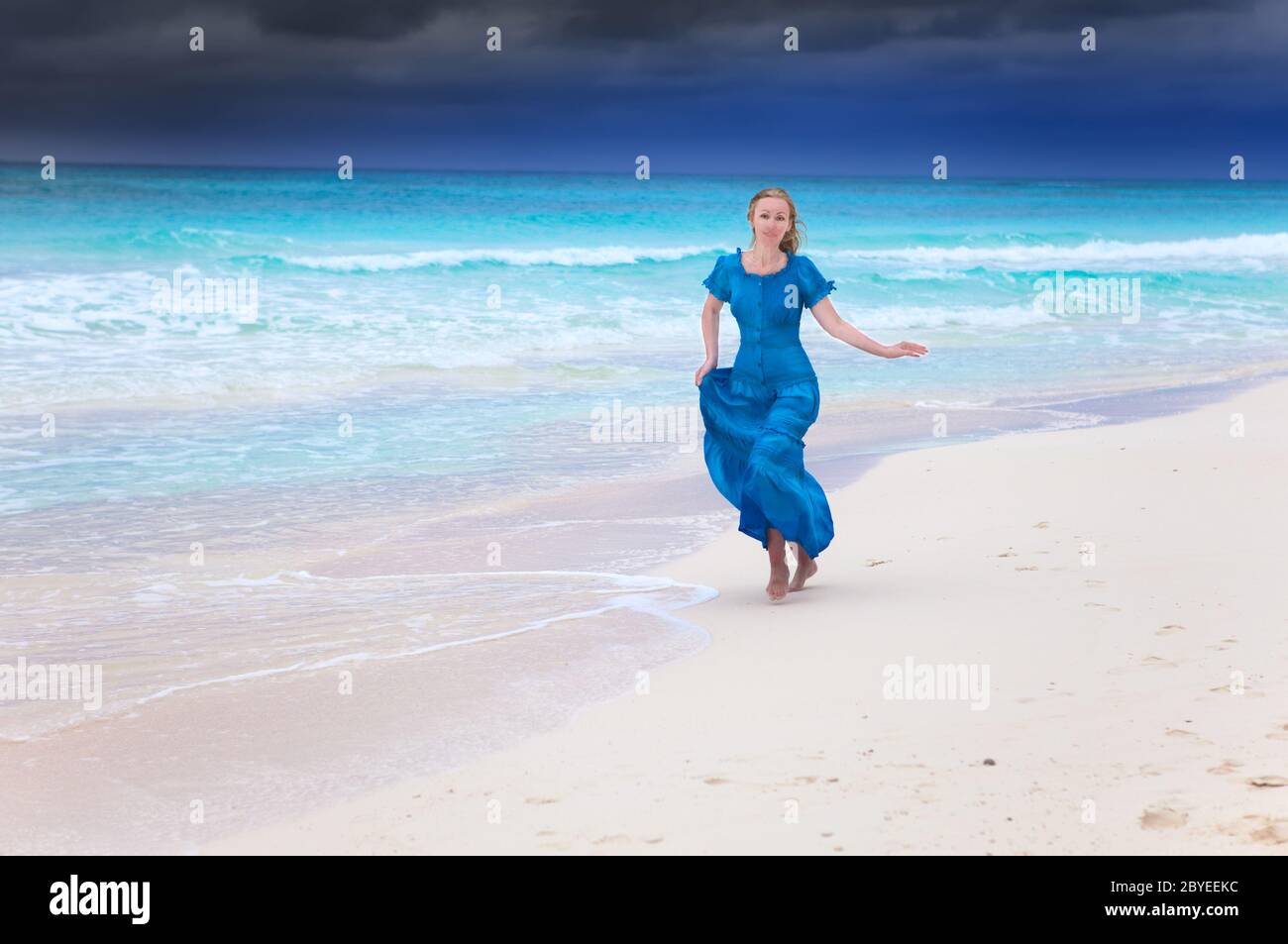 woman in a long blue dress run in a surf of storm Stock Photo - Alamy