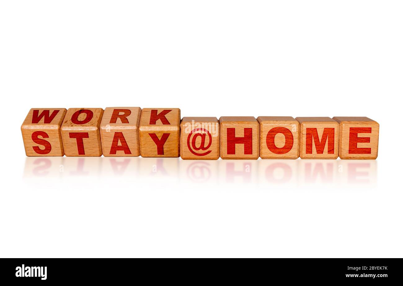Work at Home, Stay at Home due to Covid-19 coronavirus outbreak pandemic. Concept of self isolation or quarantine message engraved on wooden blocks is Stock Photo