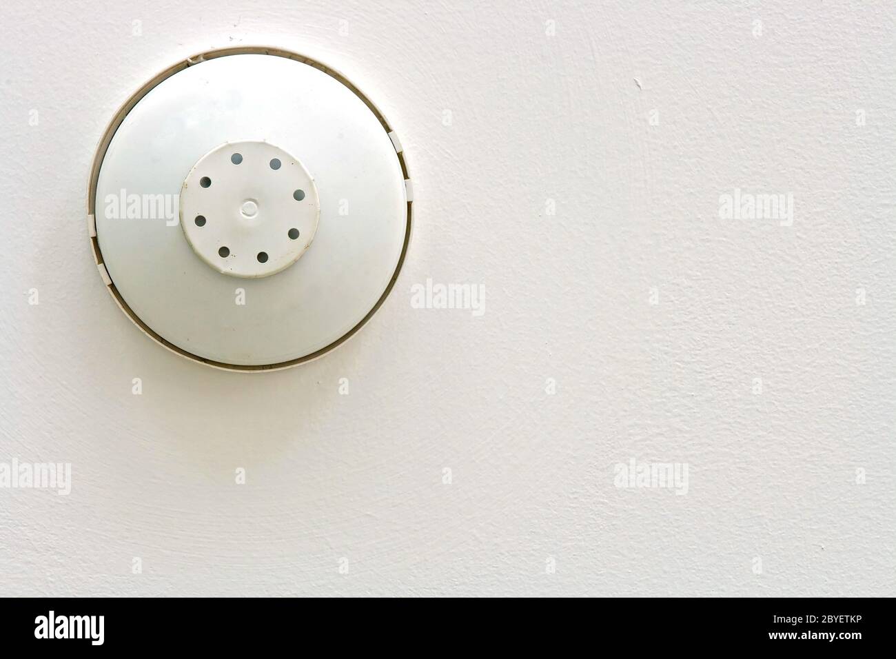 Smoke and heat alarm detecter isolated on white ceiling Stock Photo