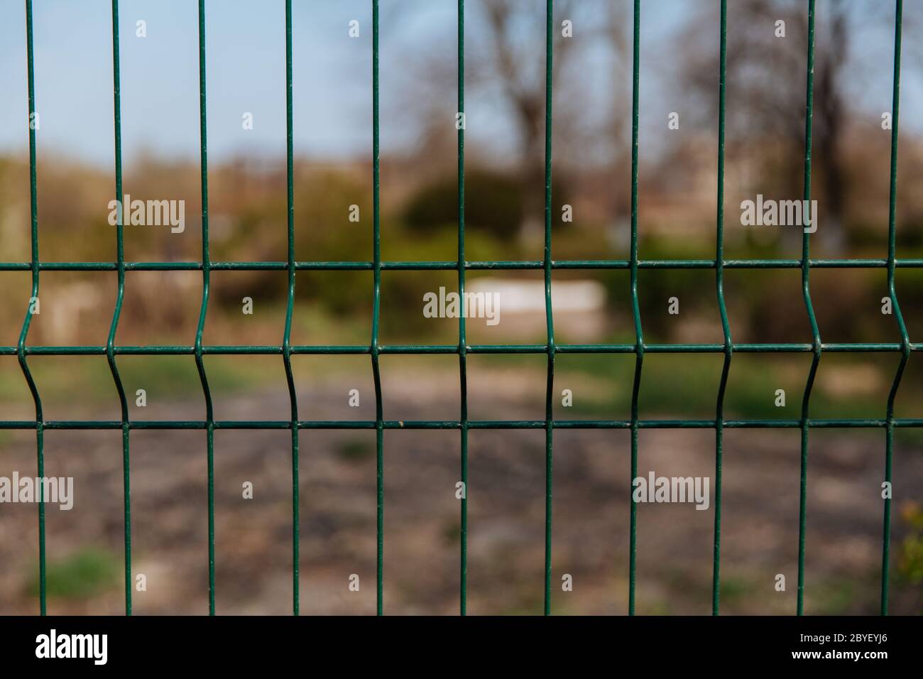 Steel grill fence with blurred wire background Stock Photo - Alamy