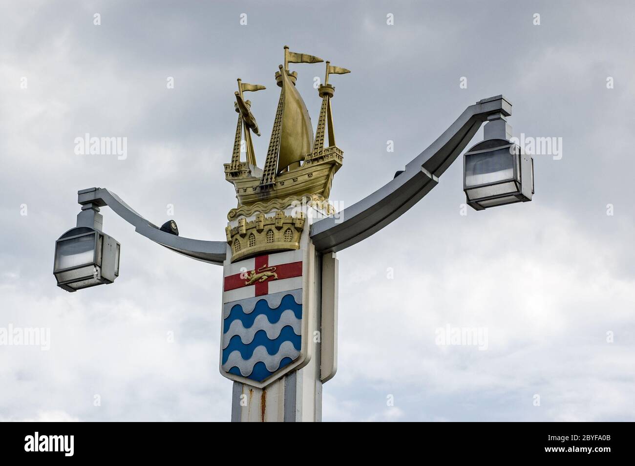 One of the four art deco style lamp posts at the entrances to Chelsea Bridge, London. A golden galleon ship sits on top of the old London County Counc Stock Photo