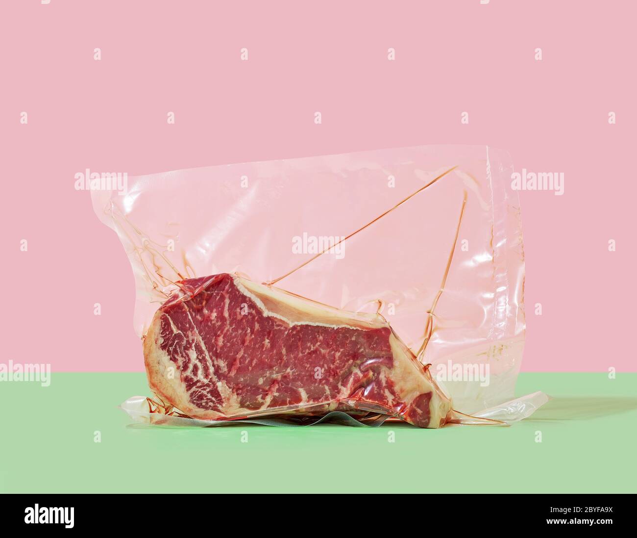 raw steak in cellophane sous vide packaging on a colored background