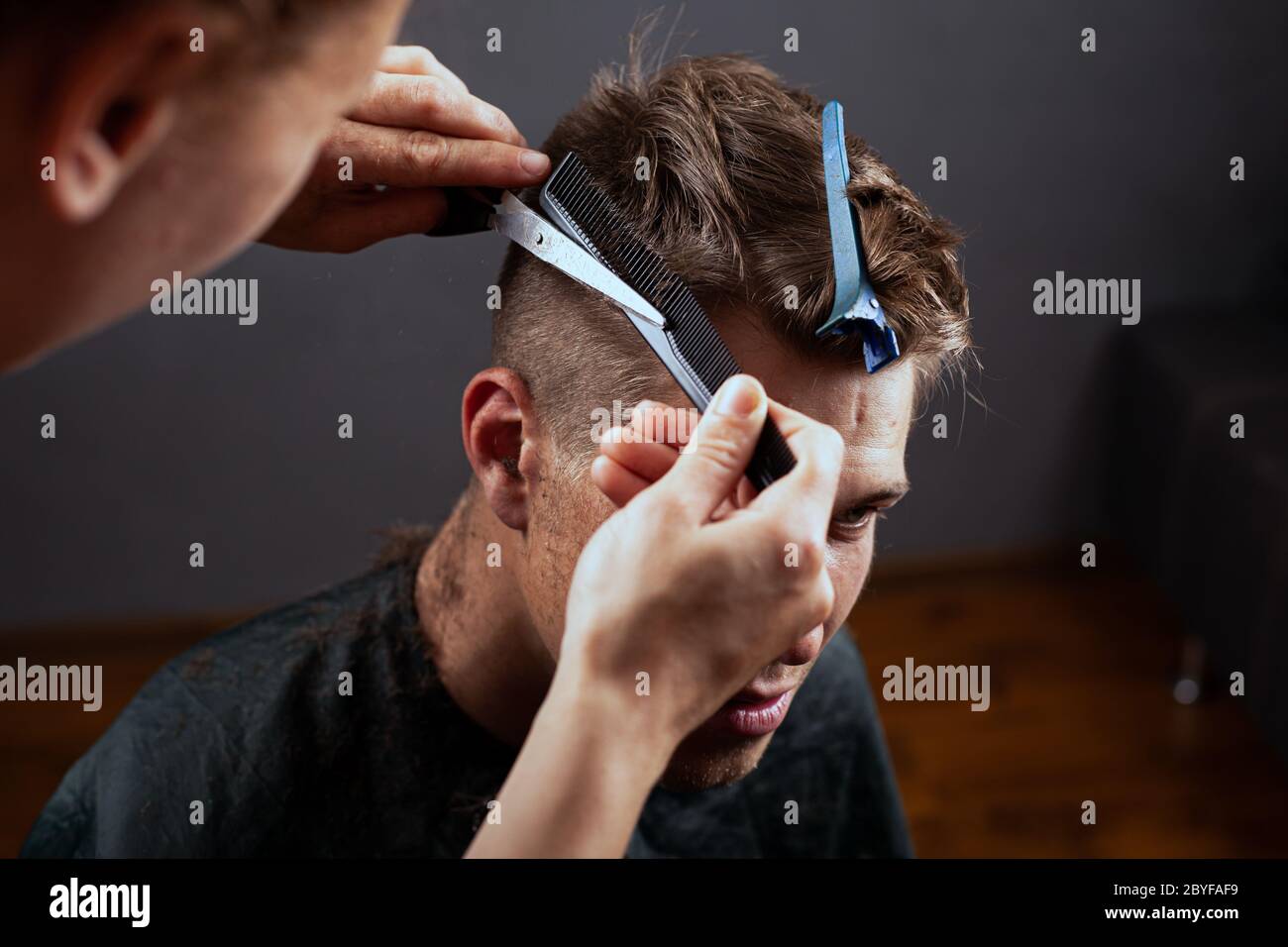 fashion haircut, young guy cuts hair at the hairdresser. barbershop. Stock Photo