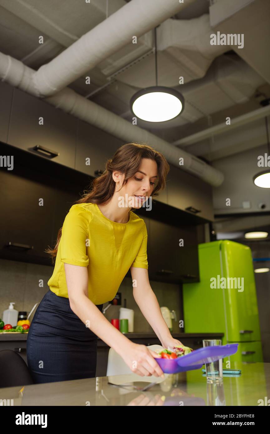 Young adult girl cleaning the lunchbox with food Stock Photo