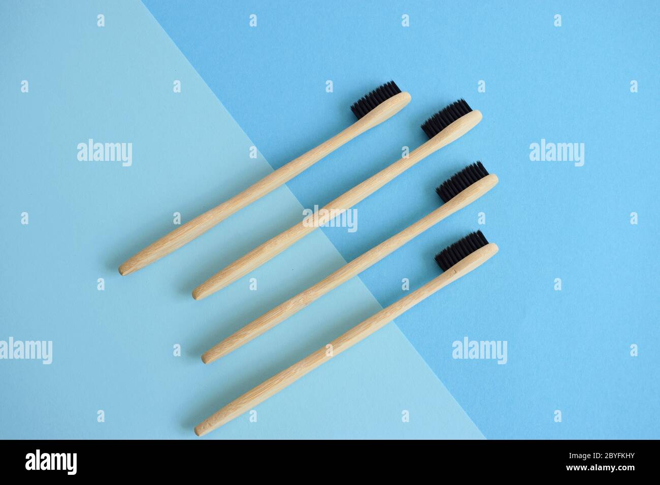 Flat lay composition with bamboo toothbrushes on lightblue and blue background Stock Photo