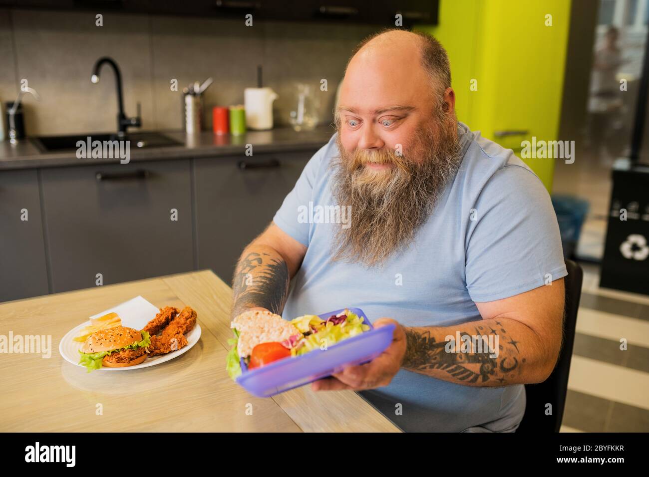 Bearded man with lunchbox with chopped vegetables Stock Photo