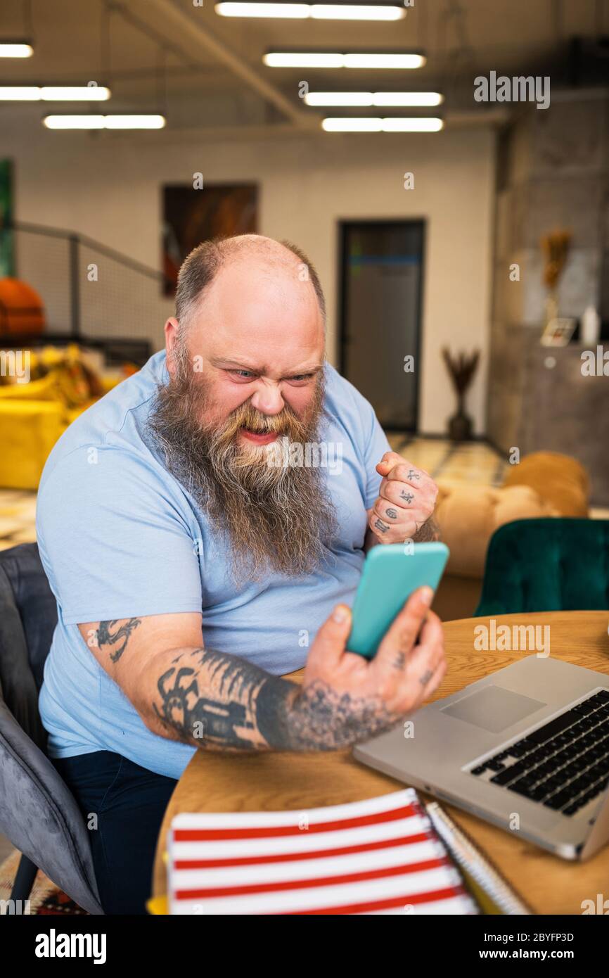 Bald man having a video call and looking angry Stock Photo