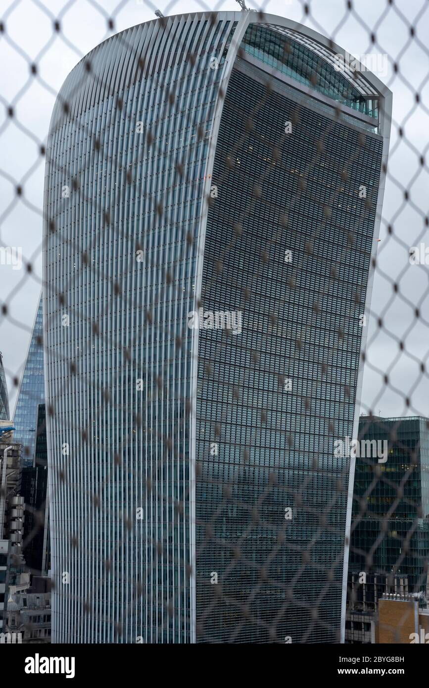 London Walkie Talkie building at 20 Fenchurch as seen through wire mesh fencing from the top of the Monument on cloudy day in London, UK as of 2020 Stock Photo