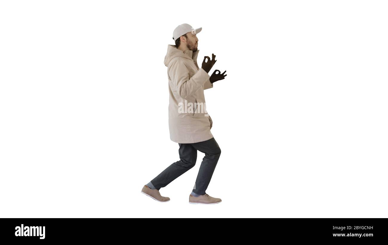 Hip-hop man singing rap, walking and making gestures on white background. Stock Photo