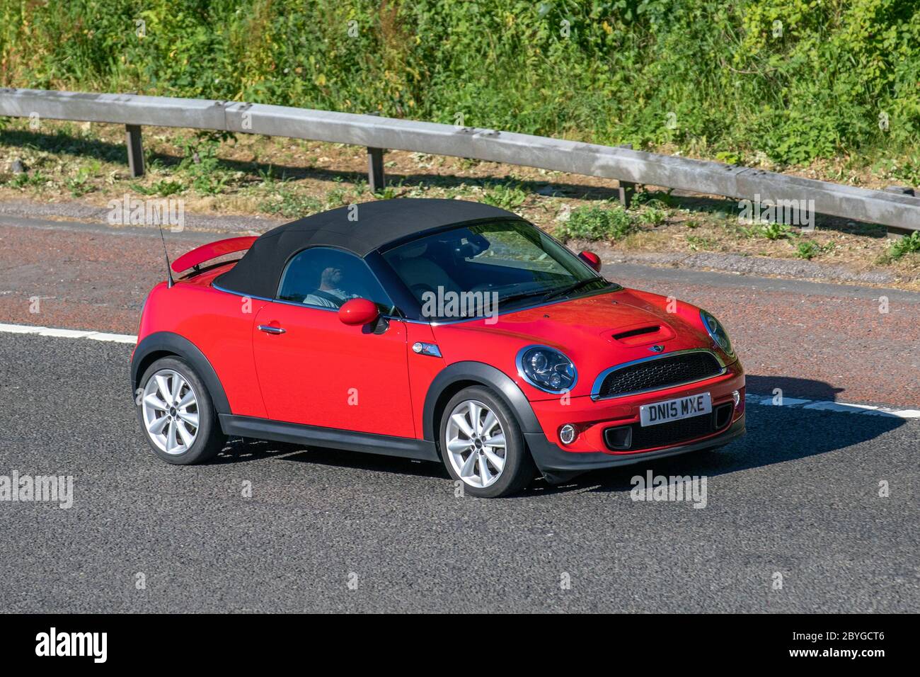 2015 red Mini Roadster Cooper SD; Vehicular traffic moving vehicles, cars driving vehicle on UK roads, motors, motoring on the M6 motorway Stock Photo