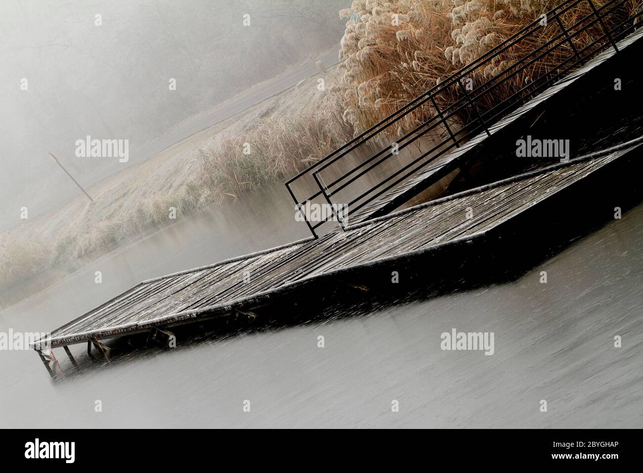 Wooden dock in a lake. Photo taken in a misty day Stock Photo