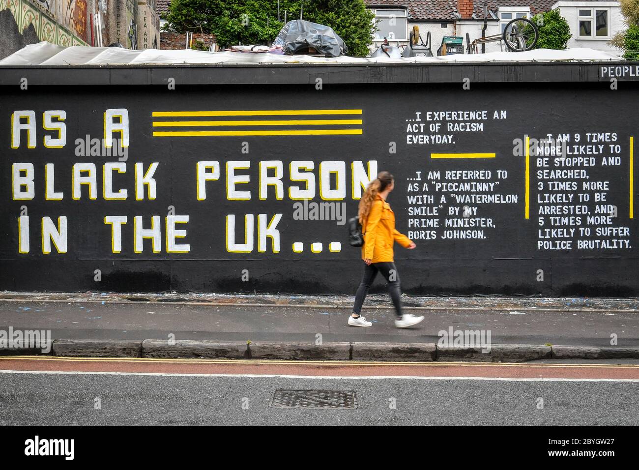 A woman looks at a graffiti art piece on Black Lives Matter on a wall ...