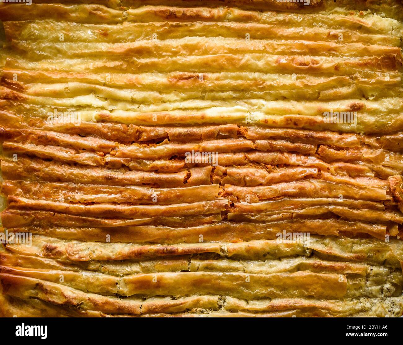 Baked homemade traditional Balkan, Bosnian, Greek, Turkish,  Serbian dish burek. Delicious homemade pastry ready to eat. Domestic pastries on backing Stock Photo