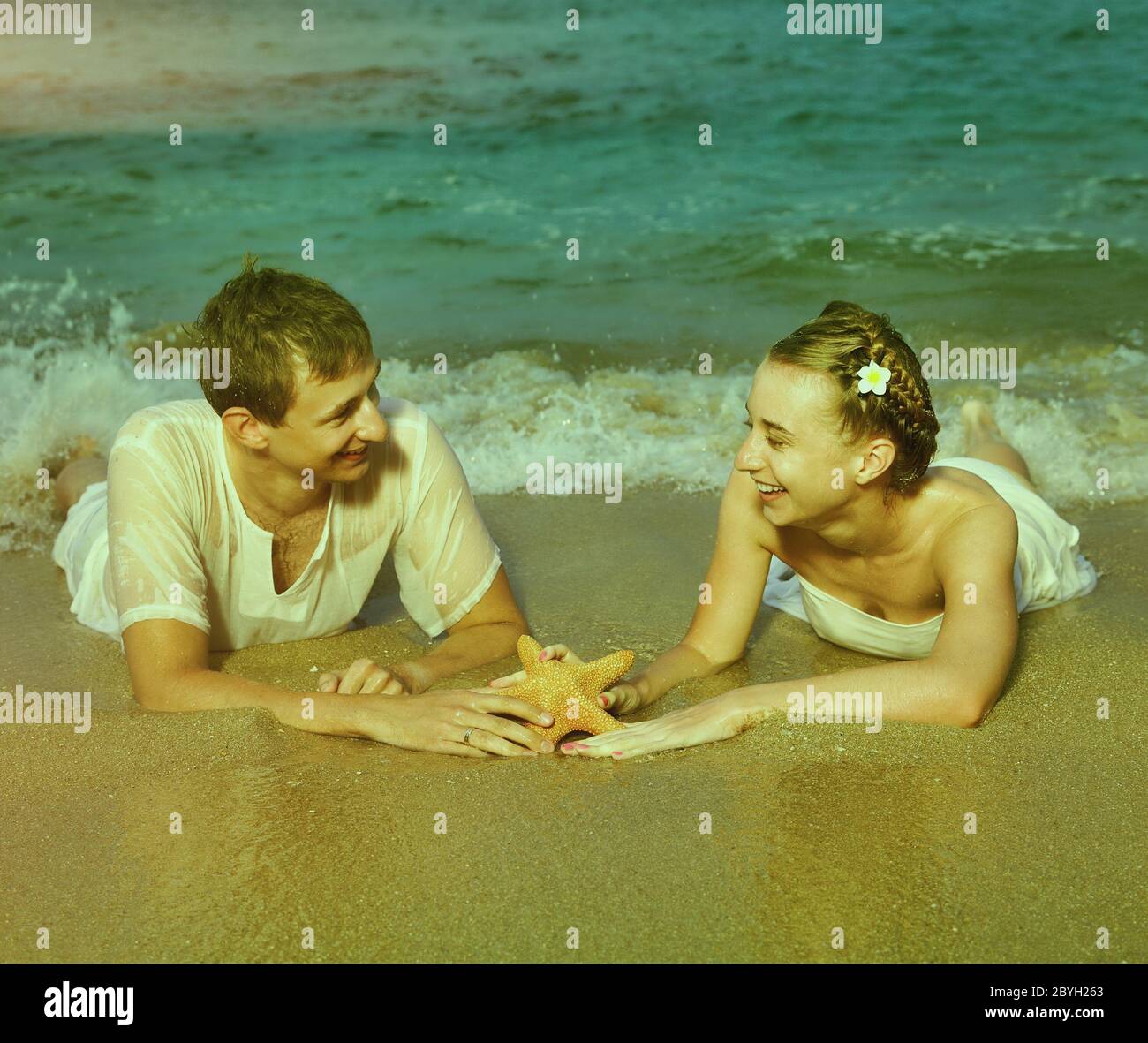 Instagram colorized vintage couple on beach portrait Stock Photo