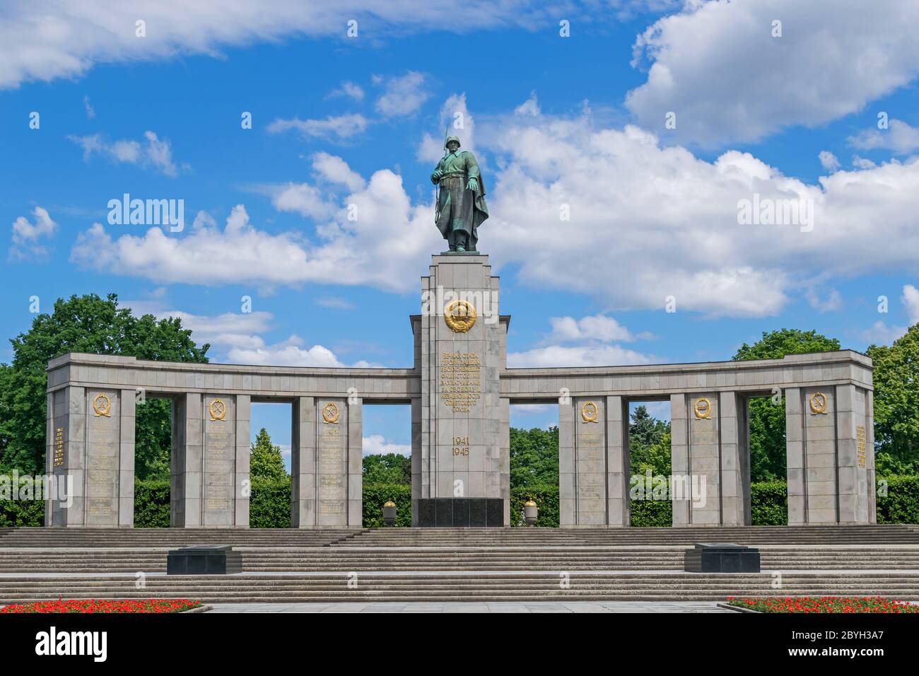 Soviet War Memorial, a curved stoa topped by a statue of a Soviet soldier and a Cyrillic inscription 'Eternal glory to heroes who fell in battle with Stock Photo