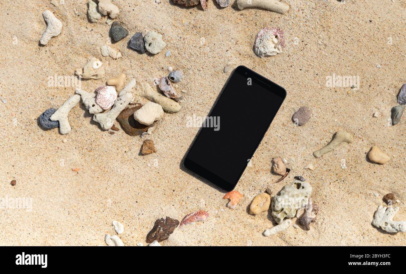 Smart phone with empty screen on tropical sand beach Stock Photo