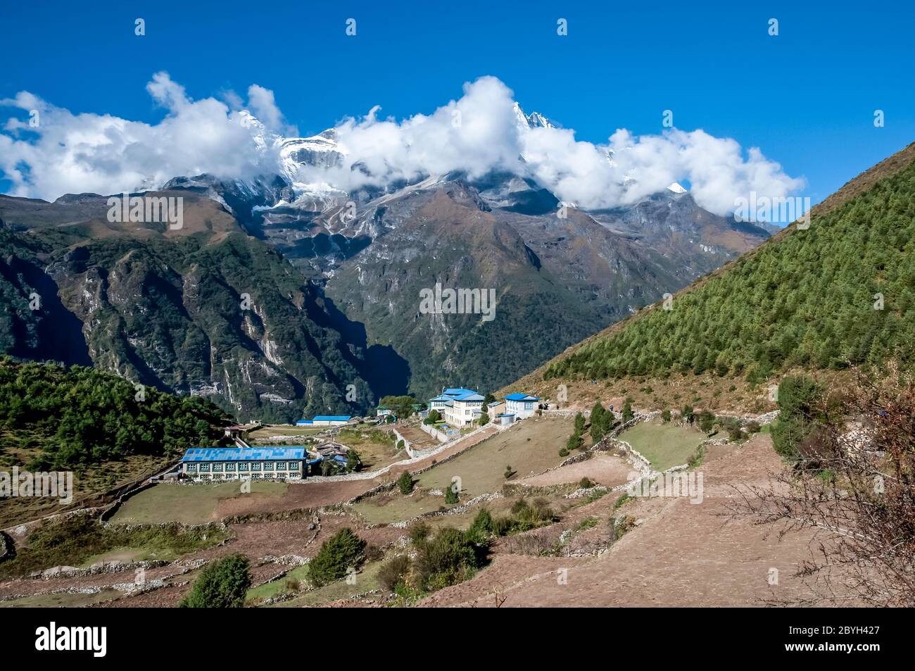 Nepal. Island Peak Trek. Colourful scenes in and around the Solu Khumbu overlooking the National Himalayan Museum and the sherpa  town of Namche Bazaar with the sacred mountain of Kumbila in the clouds Stock Photo
