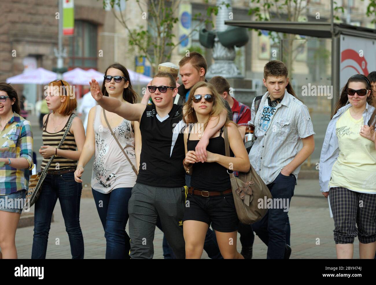 Group of smiling boys and girls walking down the street Stock Photo