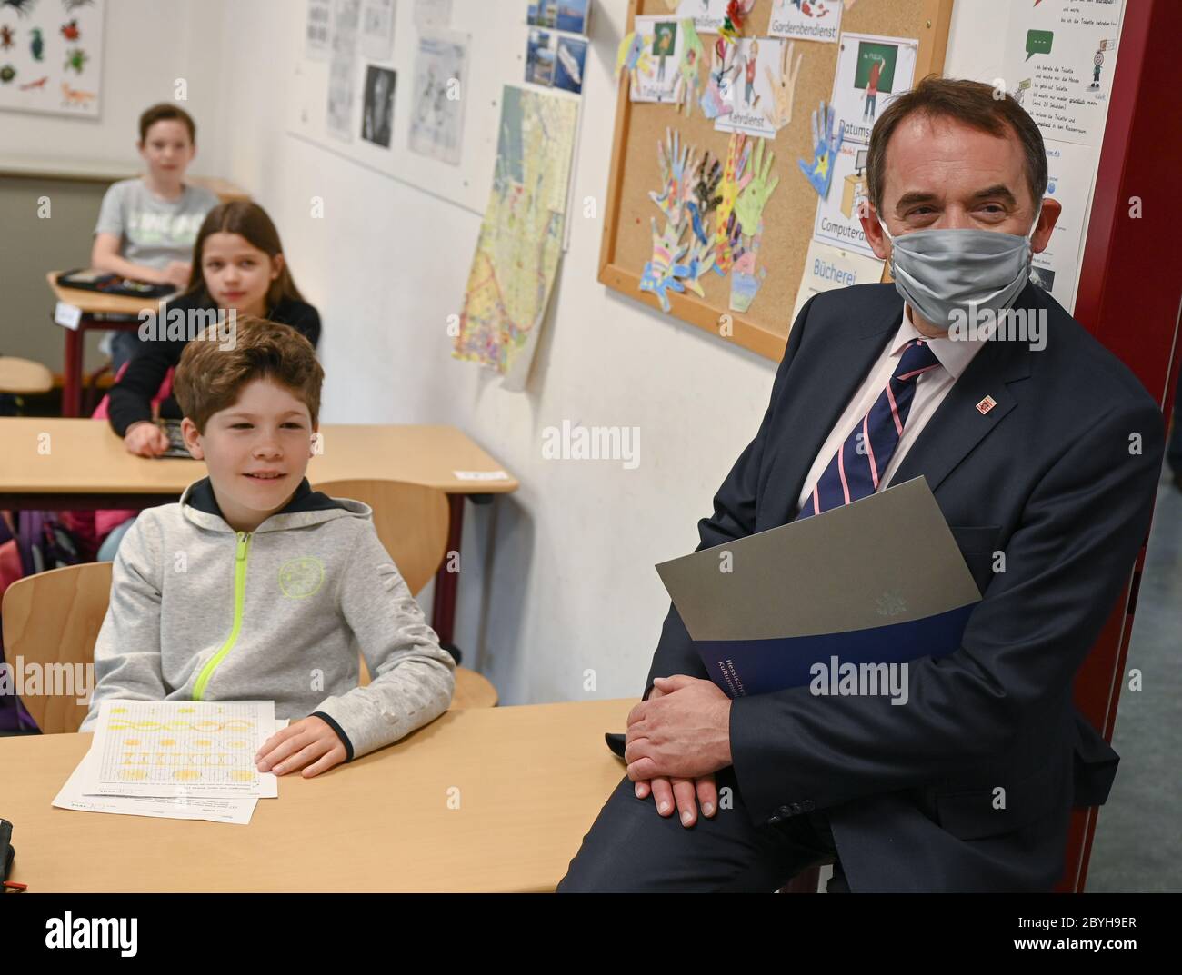 Wiesbaden, Germany. 10th June, 2020. Alexander Lorz (CDU), Minister of Education of the State of Hesse, wears a nose-mouthguard when he attends class 4b of the Robert Schumann Primary School. Hesse's elementary schools will start again on 22 June with joint attendance lessons for all children. The distance rule will then no longer apply. Credit: Arne Dedert/dpa/Alamy Live News Stock Photo