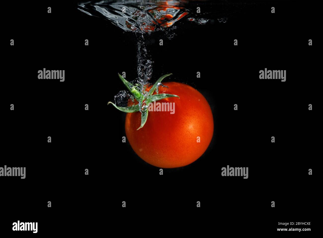 Fresh tomato dropped into water Stock Photo