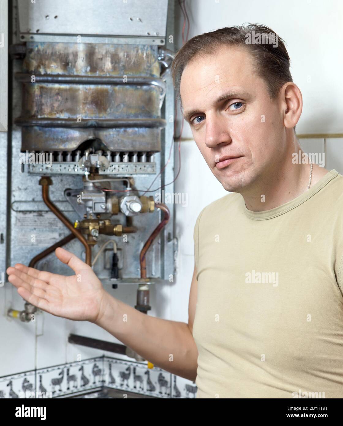 The man is upset, the gas water heater has broken Stock Photo Alamy