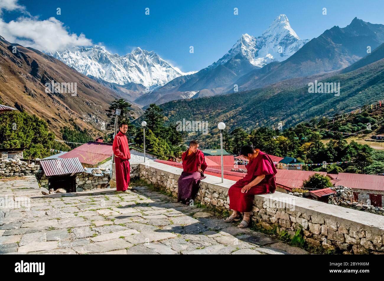 Nepal. Trek to Island Peak. Colourful scenes in and around the Thyangboche Buddhist Monastery as Buddhist Monks take a break. With the mountain of Ama Dablam and Mount Everest to the left in the distance Stock Photo