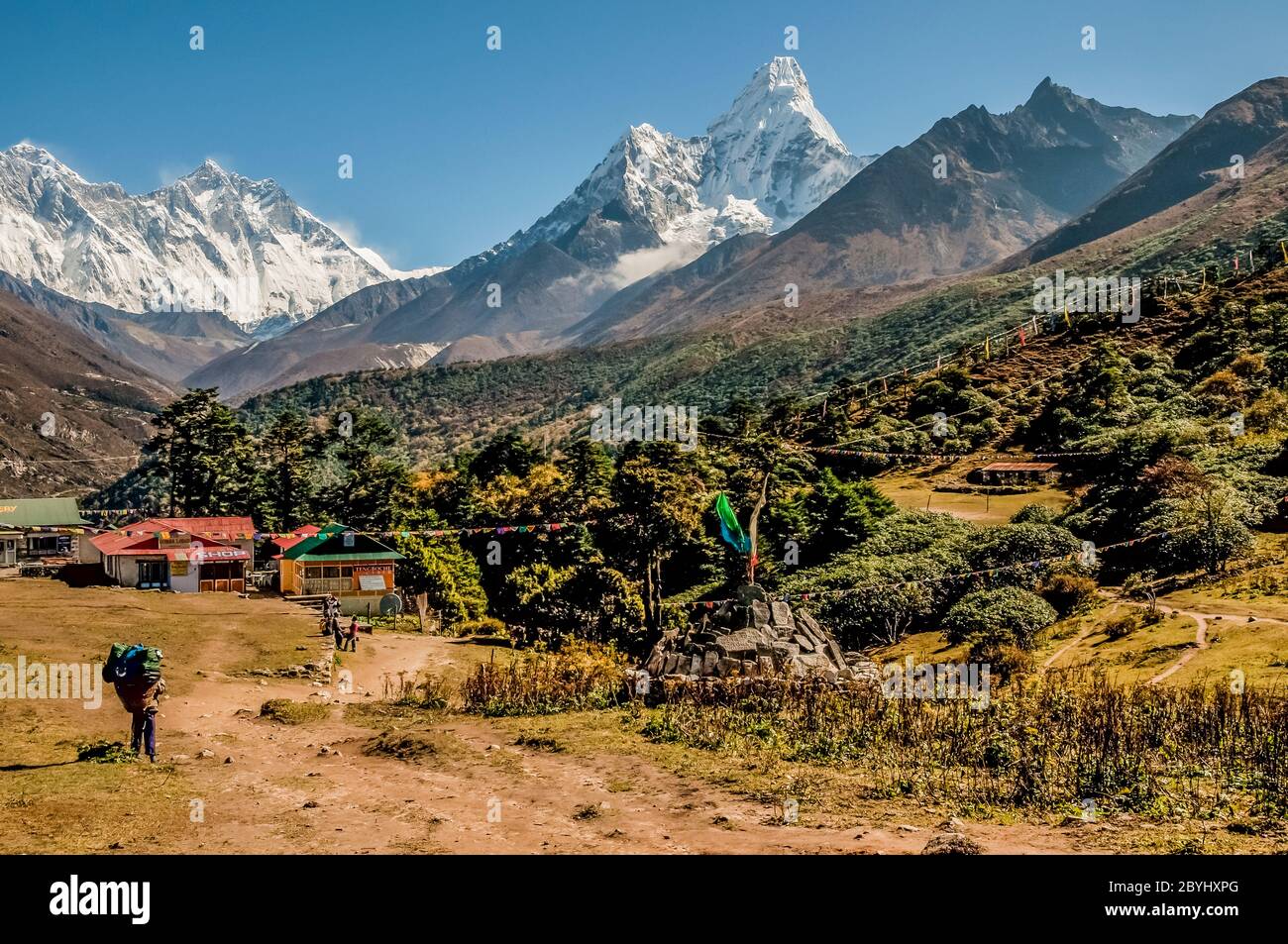 Nepal. Trek to Island Peak. Colourful scenes in and around the Thyangboche Buddhist Monastery with the mountain of Ama Dablam   and Mount Everest to the left in the distance Stock Photo