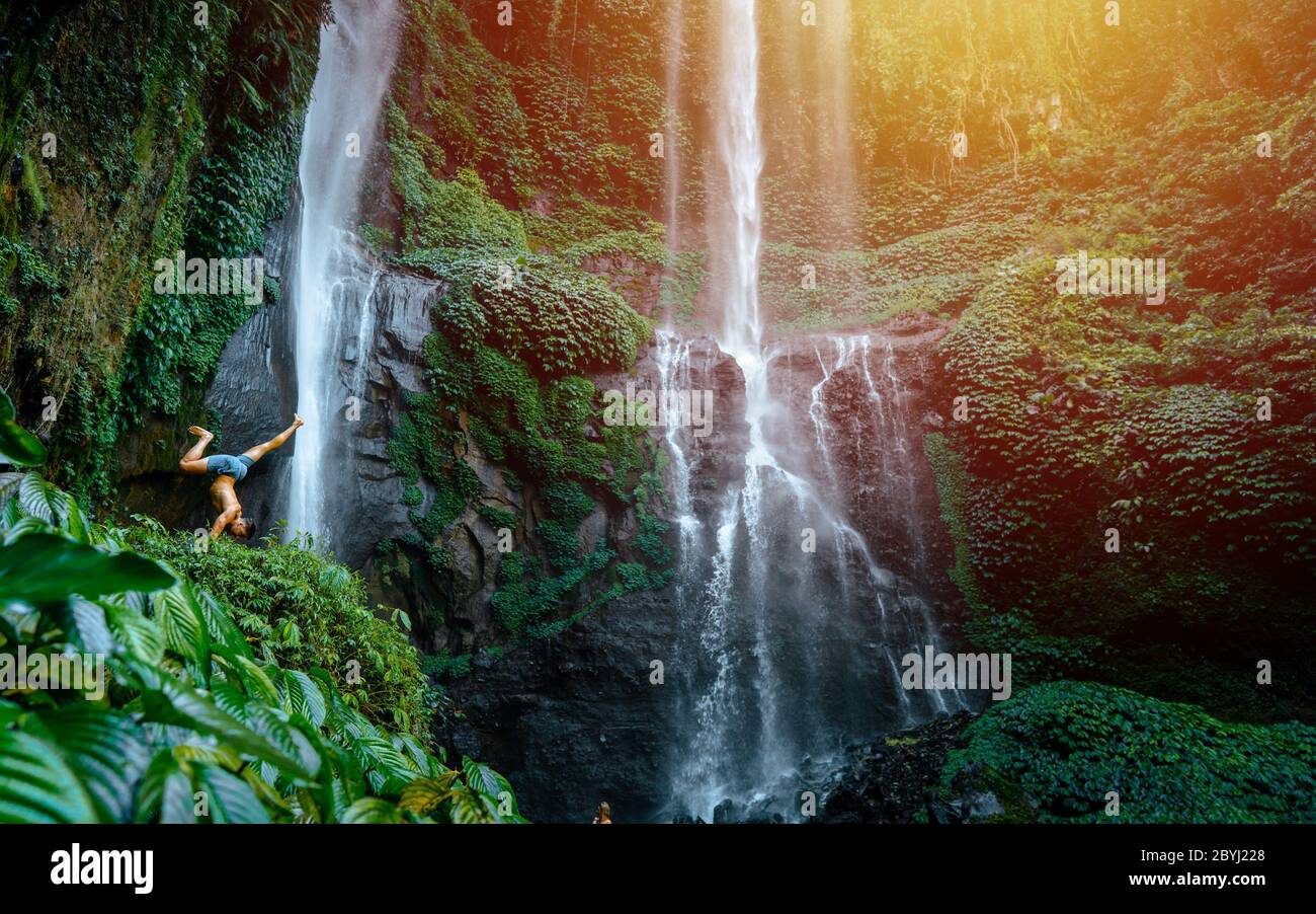 Image of a young man during sunrise. Captured on front Sekumpul Waterfall in Bali, Indonesia. Stock Photo
