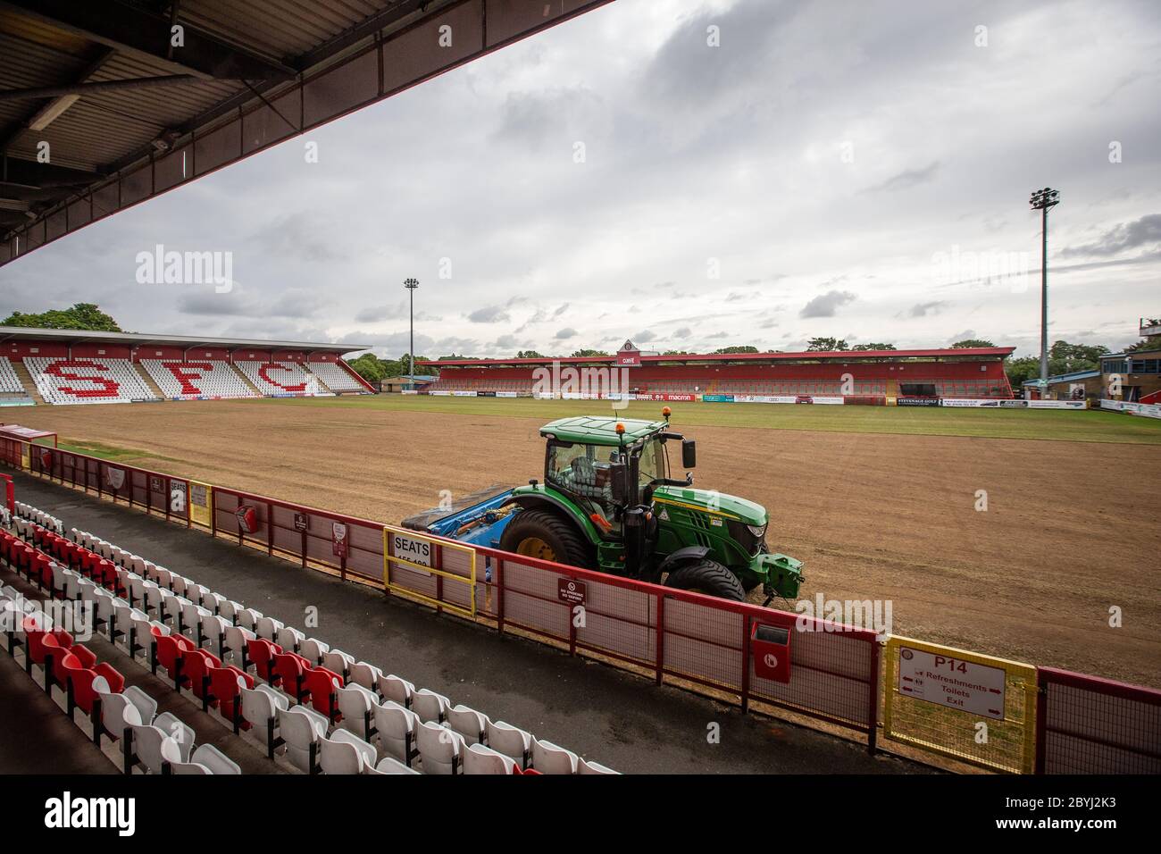 Tractor on football / soccer pitch at sports ground during end of season work by grounds staff relaying turf. Stock Photo