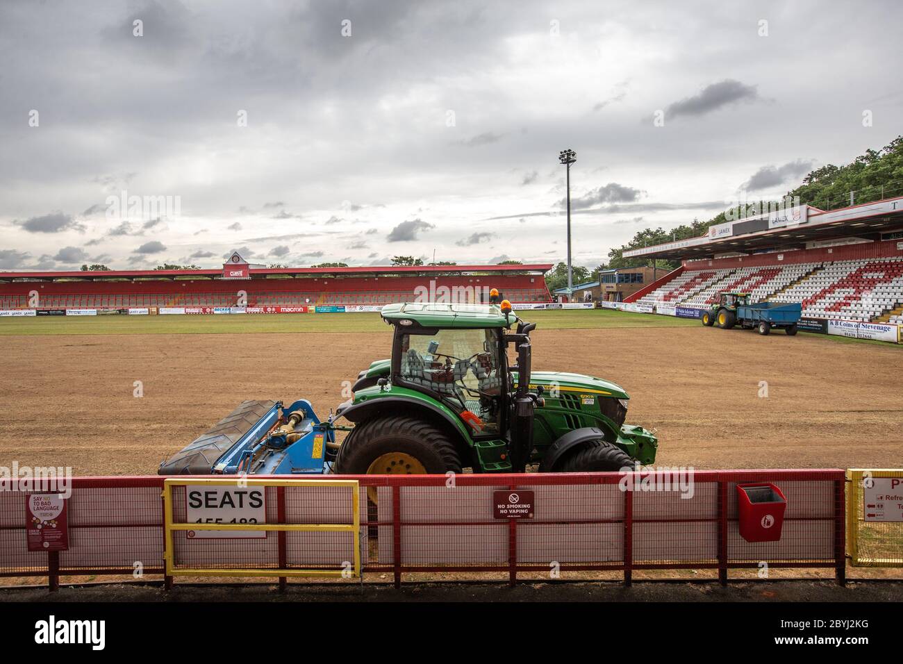 Tractor on football / soccer pitch at sports ground during end of season work by grounds staff relaying turf. Stock Photo