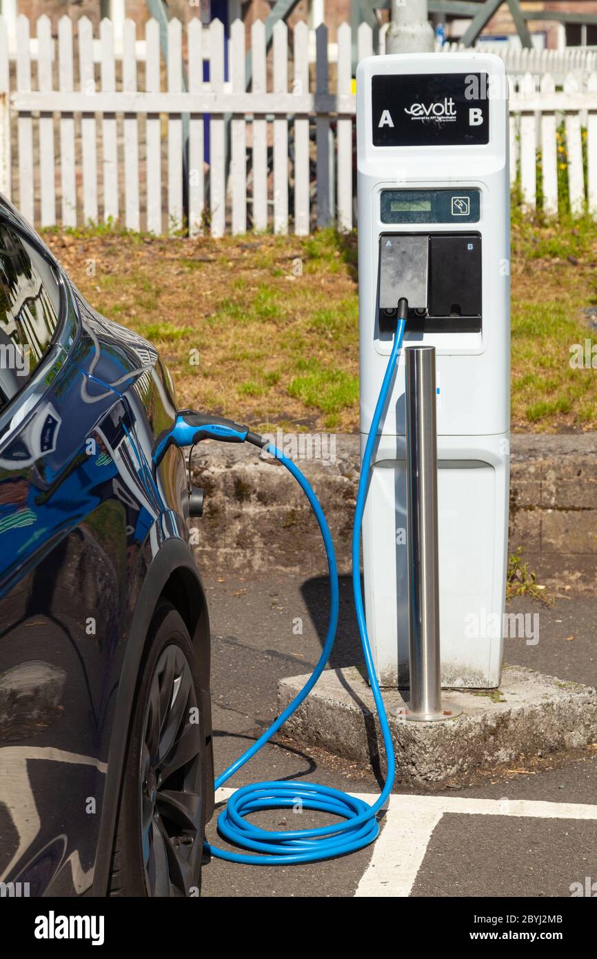 An electric Tesla car charging at a public charging station in Aberdour, Fife, Scotland Stock Photo