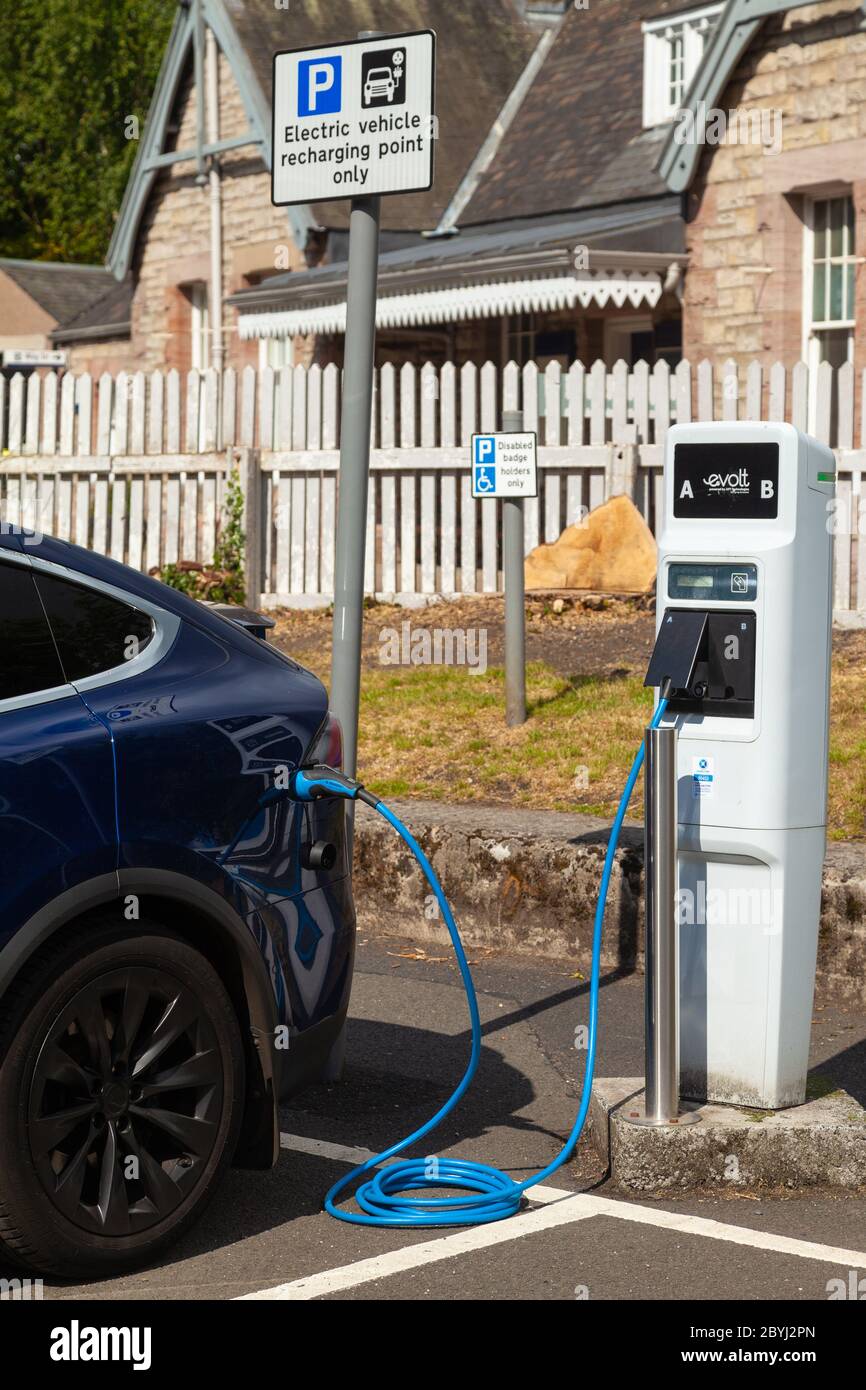 An electric Tesla car charging at a public charging station in Aberdour, Fife, Scotland Stock Photo