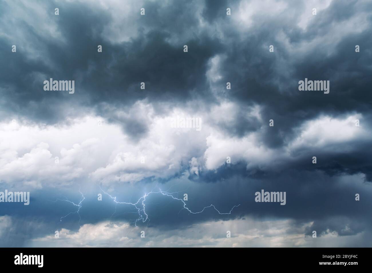 Dramatic storm clouds with rain and lightning closeup. Nature background Stock Photo