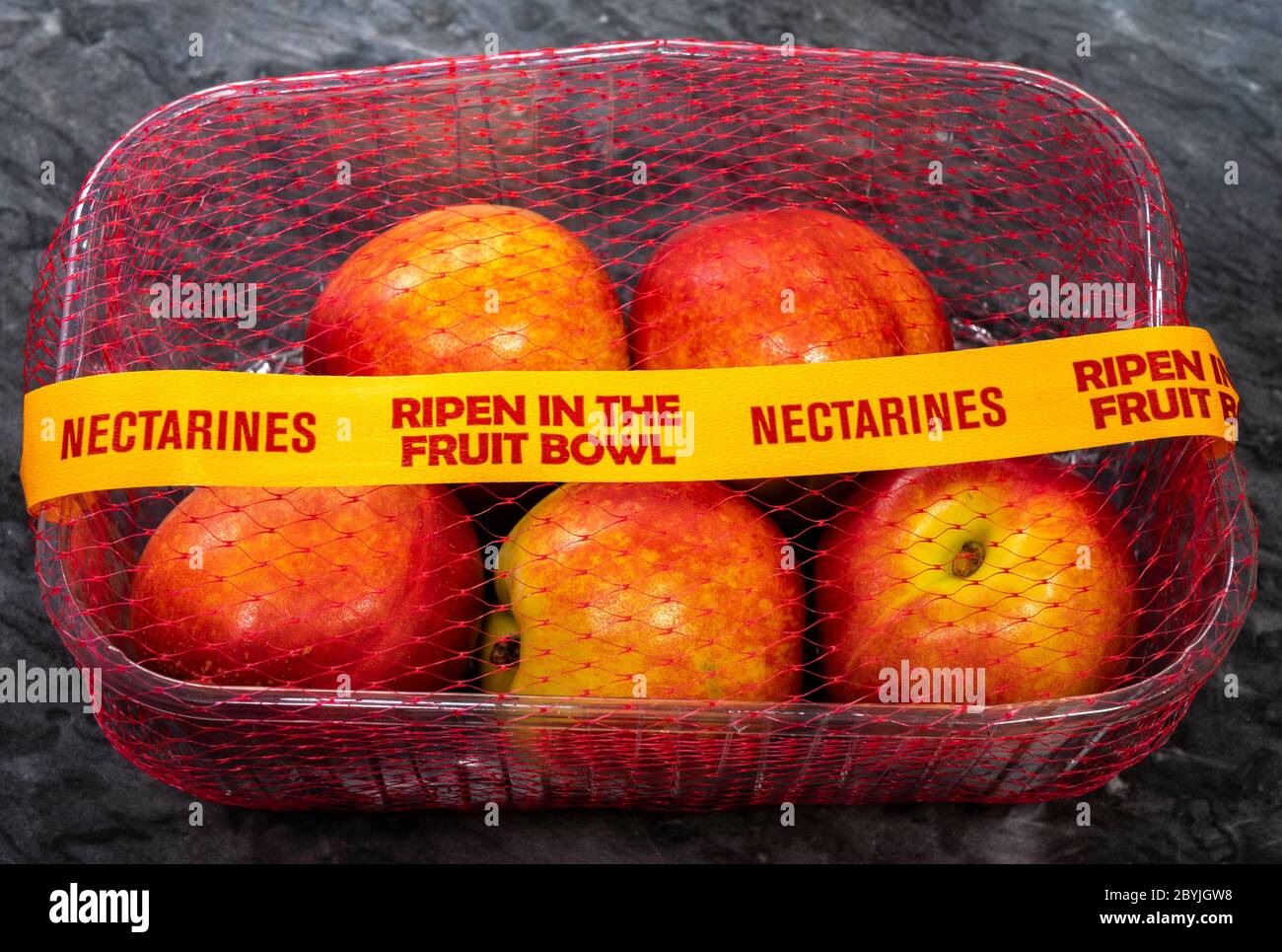 A mesh covered of five nectarines, with tape across, bearing the instruction to ‘ripen in