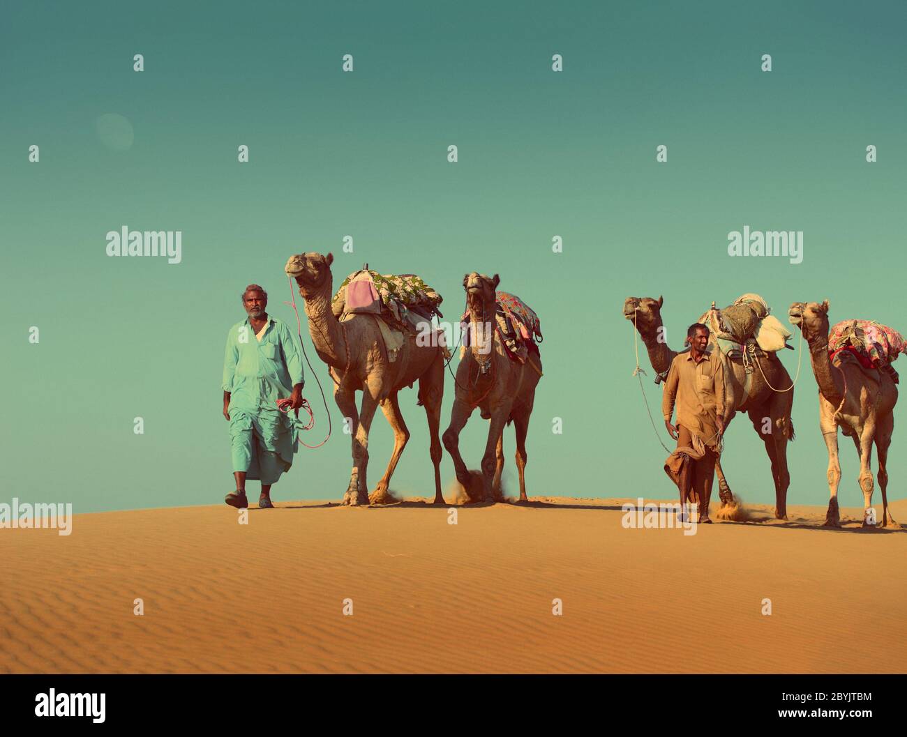 cameleers with camels in desert  - vintage retro style Stock Photo