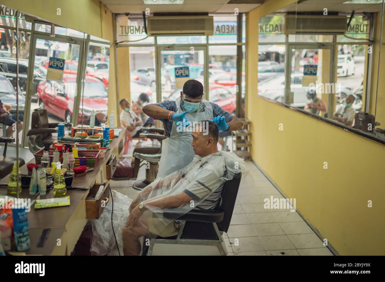 Kuala Lumpur, Malaysia. 10th June, 2020. A barber cuts hair for a customer at a barbershop in Kuala Lumpur, Malaysia, June 10, 2020. TO GO WITH 'Feature: Malaysians brave adventure in barbershops as COVID-19 restrictions ease' Credit: Zhu Wei/Xinhua/Alamy Live News Stock Photo