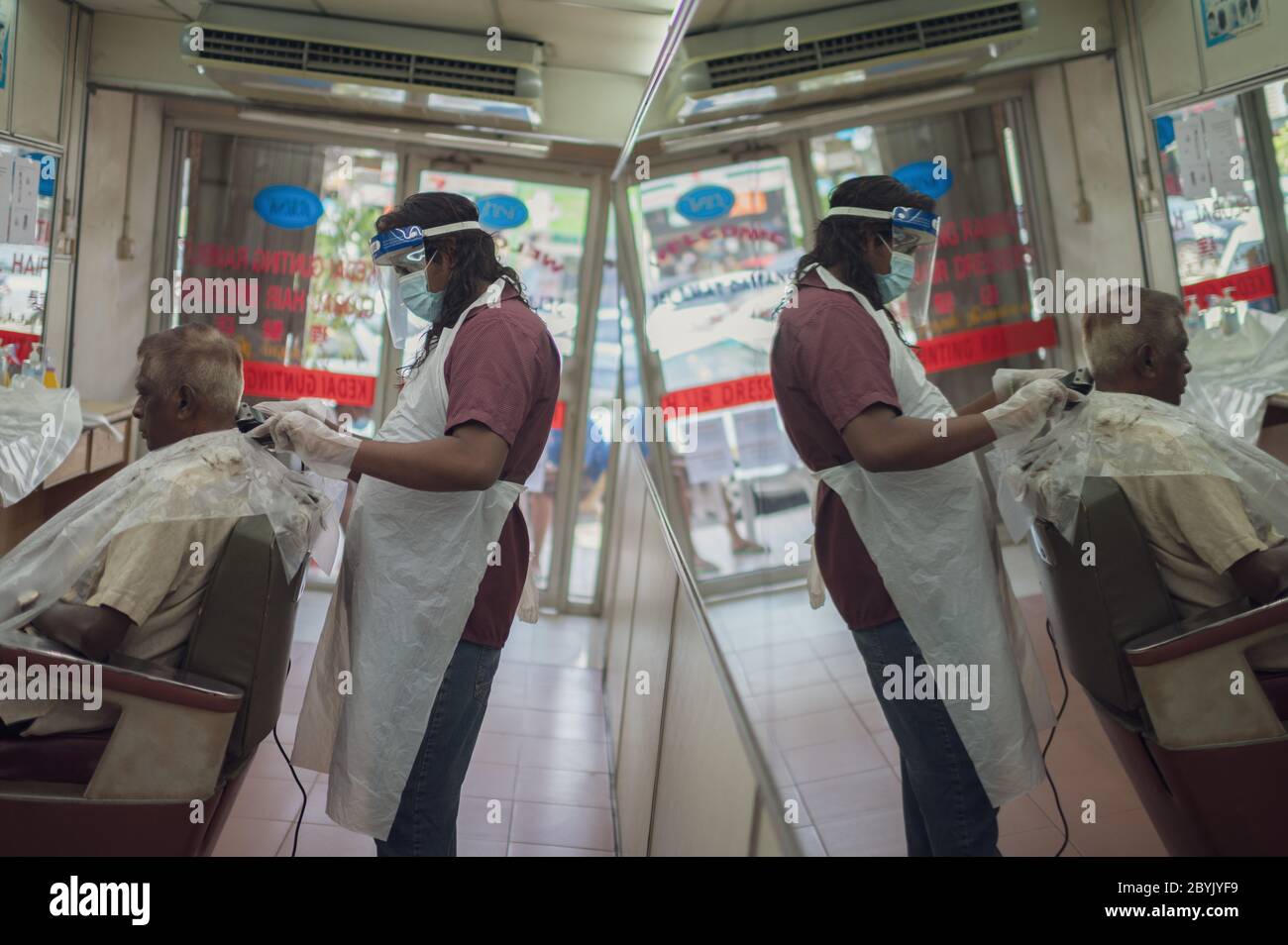 Kuala Lumpur, Malaysia. 10th June, 2020. A barber cuts hair for a customer at a barbershop in Kuala Lumpur, Malaysia, June 10, 2020. TO GO WITH 'Feature: Malaysians brave adventure in barbershops as COVID-19 restrictions ease' Credit: Zhu Wei/Xinhua/Alamy Live News Stock Photo