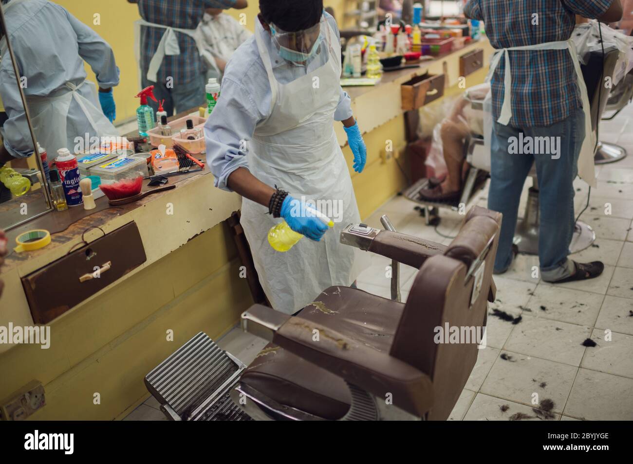 Kuala Lumpur, Malaysia. 10th June, 2020. A barber sprays disinfectant to a seat at a barbershop in Kuala Lumpur, Malaysia, June 10, 2020. TO GO WITH 'Feature: Malaysians brave adventure in barbershops as COVID-19 restrictions ease' Credit: Zhu Wei/Xinhua/Alamy Live News Stock Photo