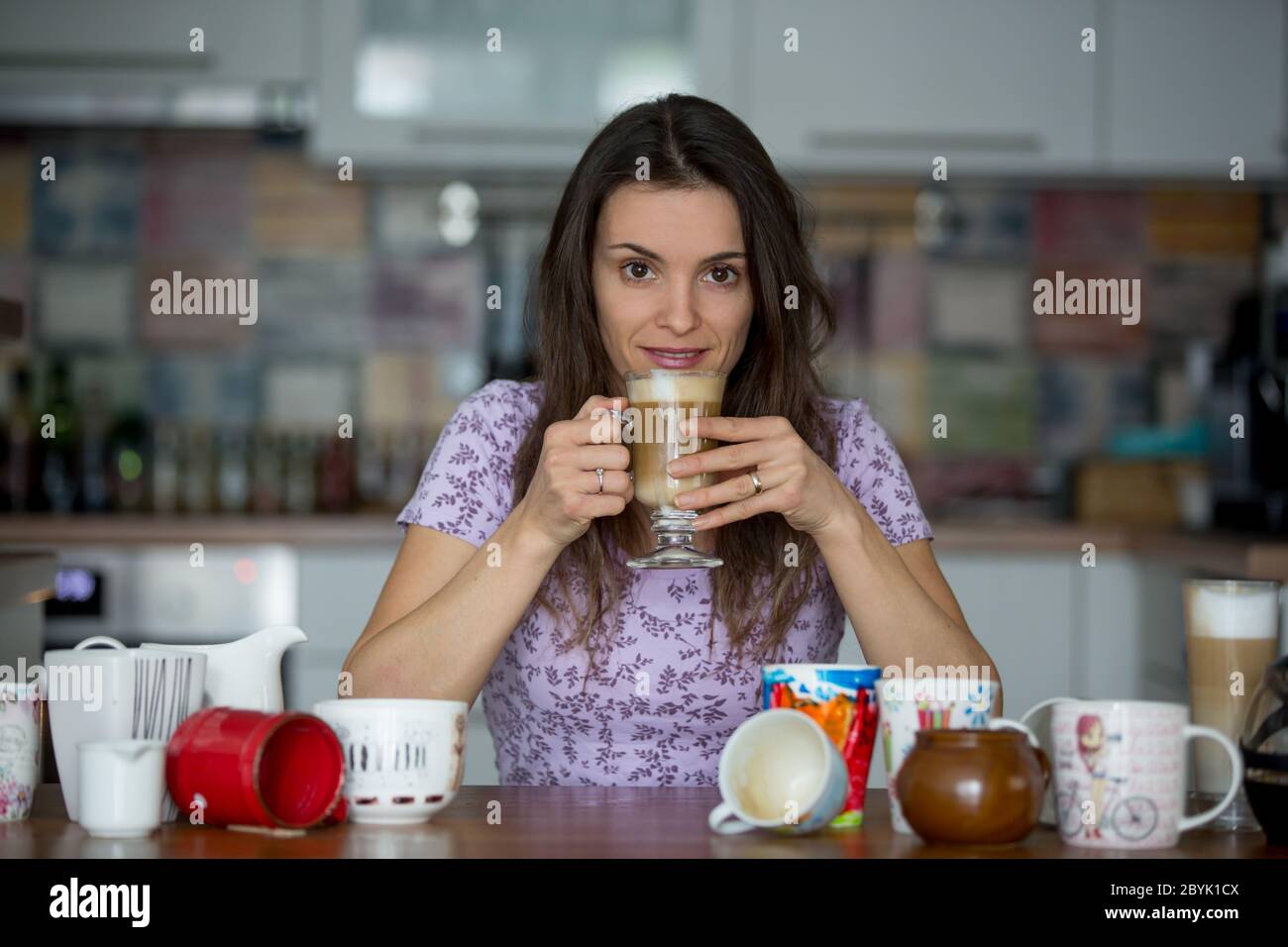 Young mom, drinking many coffees in the morning with her toddler child