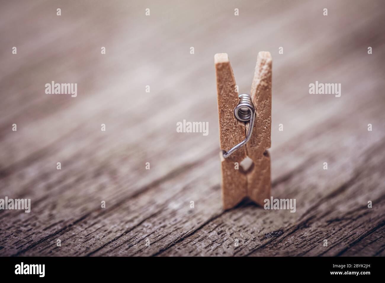 Wooden clothespin on vintage rustic background. The beauty of simple