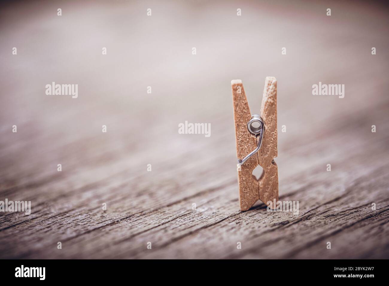 Wooden clothespin on vintage rustic background. The beauty of simple