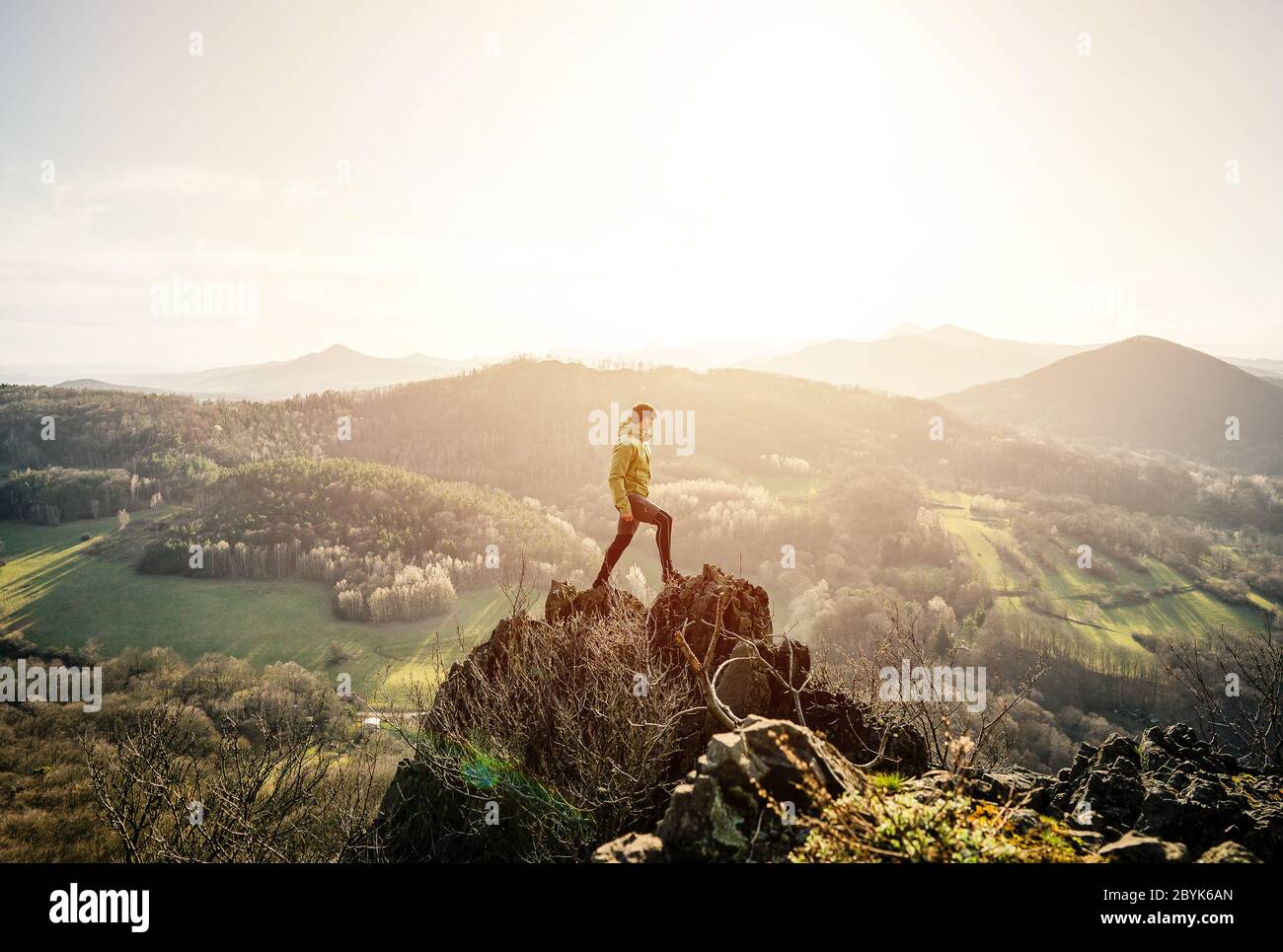 Back view of man wanderlust tours excited with natural environment and scenery during during colorful sunset. Hiker exploring nature in wild trip Stock Photo