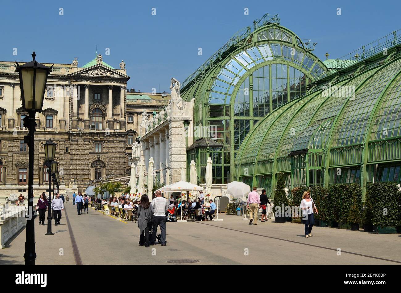 Vienna, Austria - April 24th 2011: unidentified people walk and take a rest in the public Burggarten with new renovated palm house cafe with the Hofbu Stock Photo