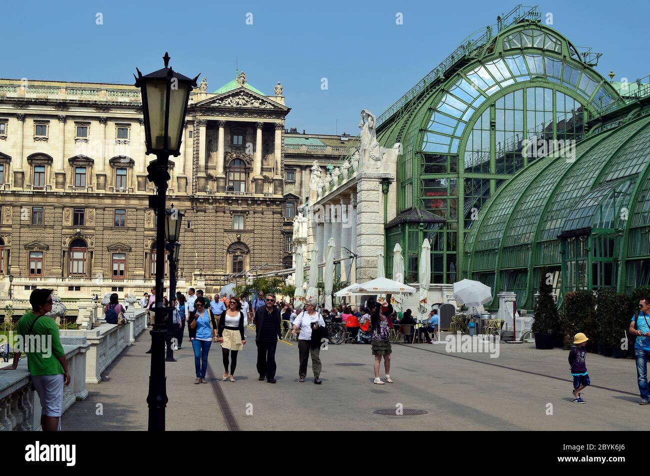 Vienna, Austria - April 24th 2011: unidentified people walk and take a rest in the public Burggarten with new renovated palm house cafe and Hofburg bu Stock Photo