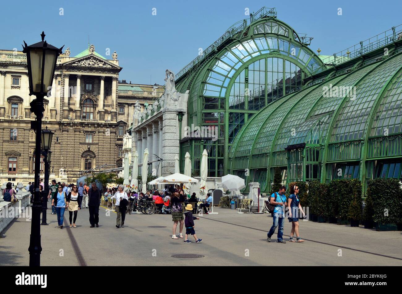 Vienna, Austria - April 24th 2011: unidentified people walk and take a rest in the public Burggarten with new renovated palm house cafe and Hofburg bu Stock Photo