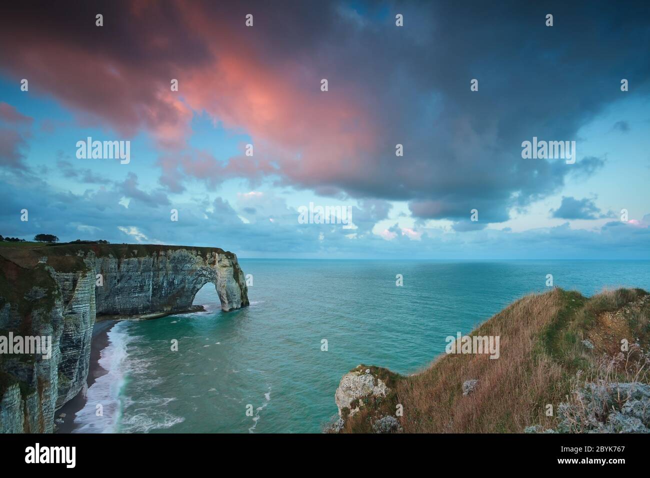 pink stormy sunrise over cliffs in ocean Stock Photo - Alamy