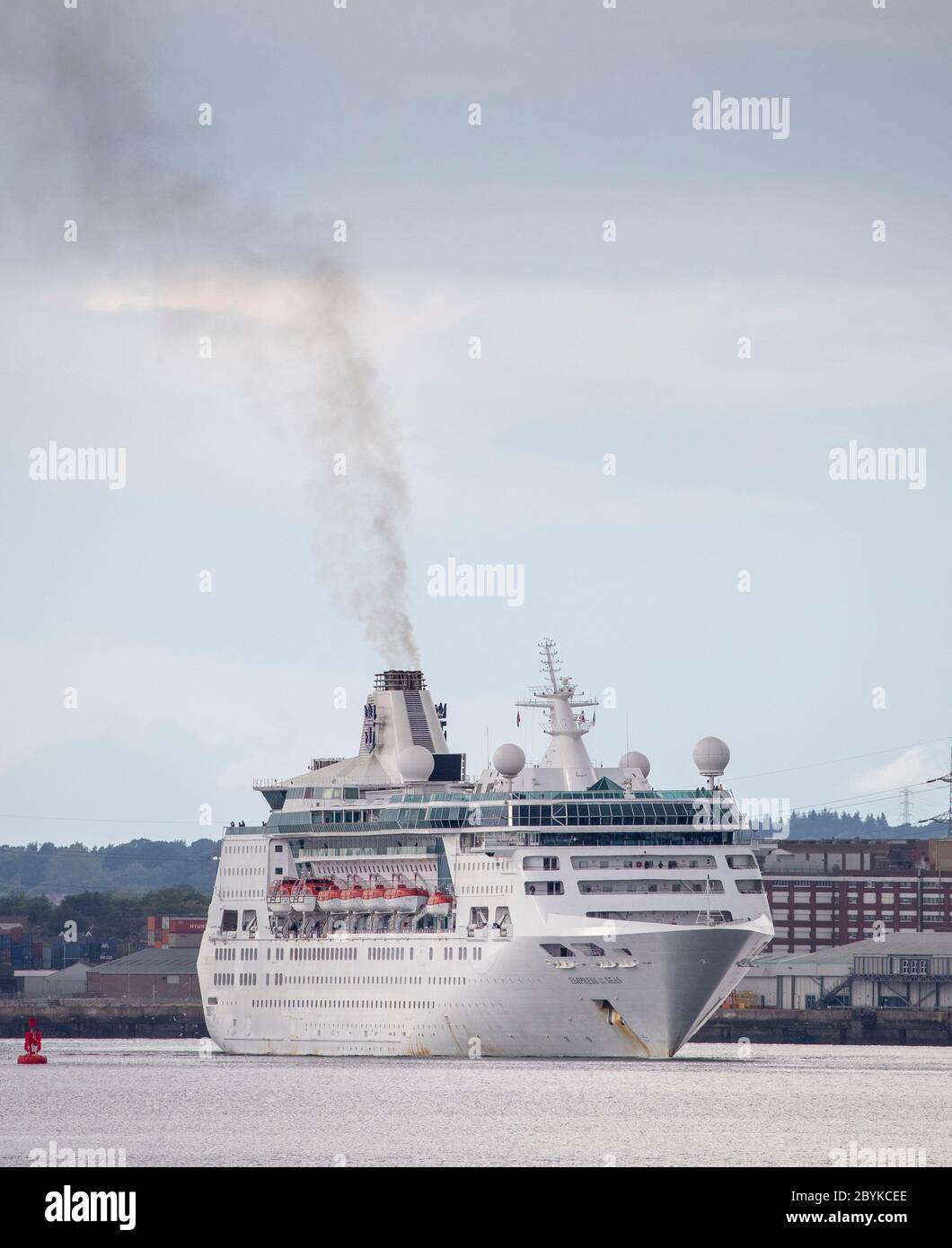Cruise ship with smoke coming out of its funnel leaving Southampton Docks, Hampshire, UK. Air pollution is an issue in Southampton. Stock Photo
