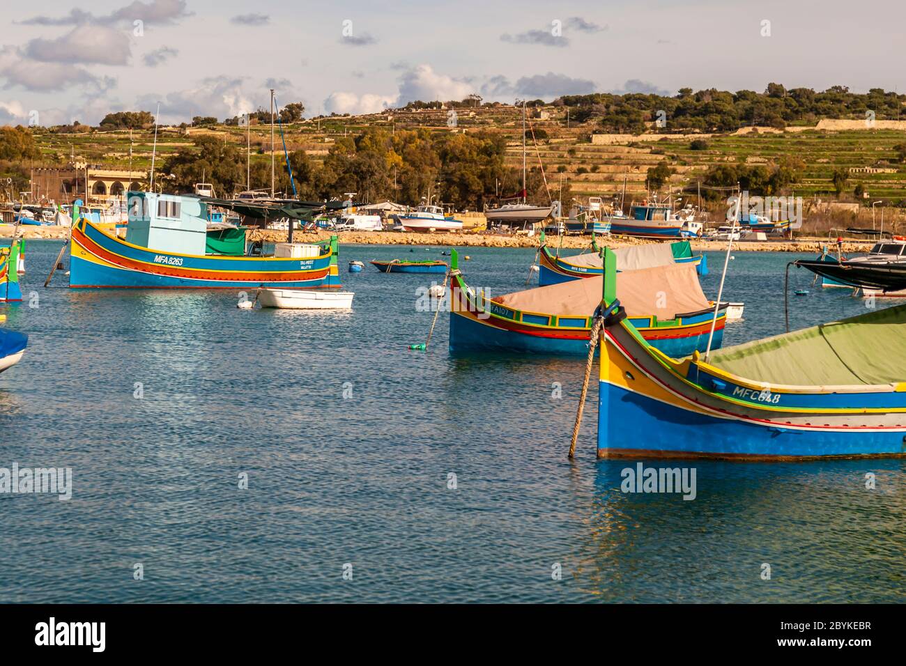 Colorful Boats at fishing port in Marsaxlokk, in the southeast of Malta. There are ports large and imposing like that of the capital Valetta, but small fishing ports characterize the varied coast of Malta and Gozo Stock Photo